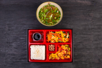 Lunch box with chicken soup and seafood stewed with vegetables and sesame