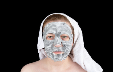 Cosmetic bubble mask with charcoal on the face of a young woman.