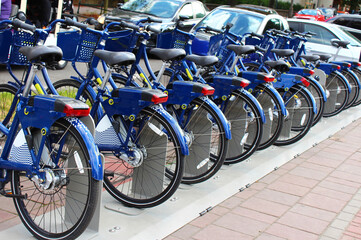 Blue city bikes in Poland, parked in a row, ready for citizens and tourists, where everyone can rent public bikes. Bicycle rental in the city.