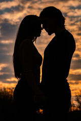 Fototapeta na wymiar Silhouette of romantic couple in love, man and women in sunset sky. Romantic of relationships between couple love in the garden