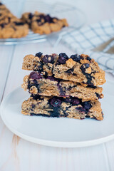 Stack of freshly baked oat blueberry scones on white plate. Sweet food with natural ingredients. Vegan gluten free pastry.