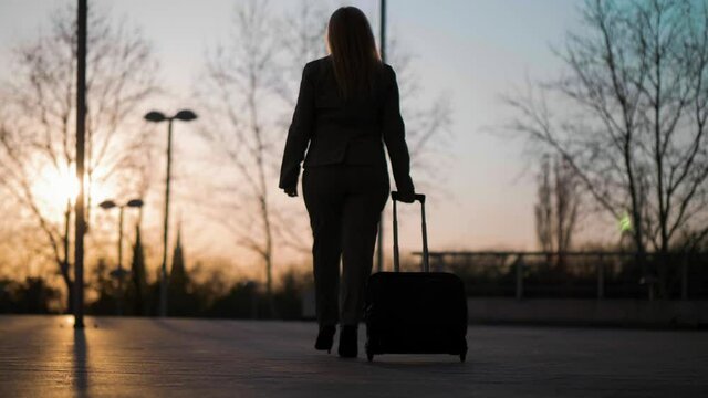 Back view of businesswoman walking with a suitcase. Slow motion stock video