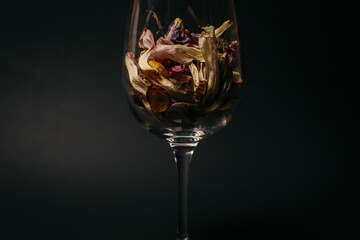dry flower petals in a glass. black background. . High quality photo