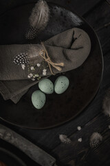 Plate with green chocolate eggs napkin and small white flowers. Ester composition.