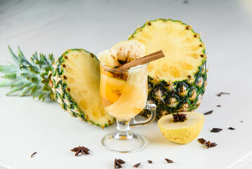 Mulled wine, grog and punch hot alcohol drinks on the table with seasonal decoration: pineapple,...