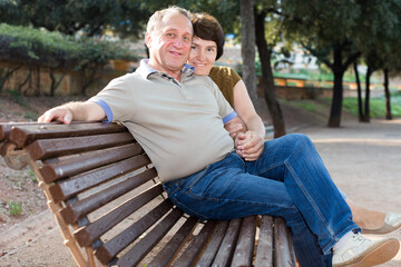 mature man with a woman sitting on bench