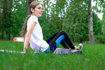 Teenager girl doing yoga in the park. Teenager resting after sports activities