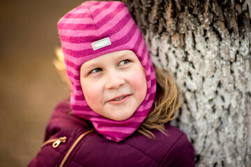 funny girl in warm clothes in a spring park, selective focus