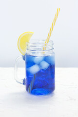 Hawaiian Blue Lagoon summer alcoholic cocktail with vodka, liqueur, tonic, pineapple juice and ice in glass jar