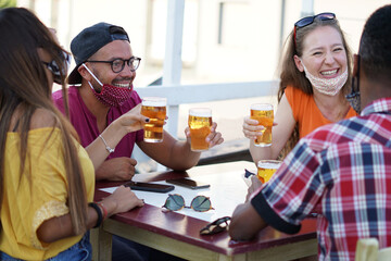 Friends cheering with beer and smiling laughing with each other