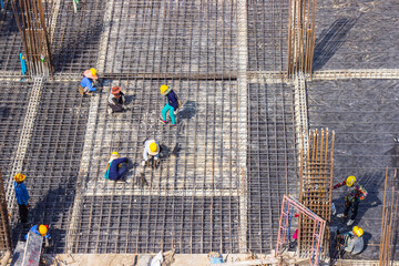 Construction workers fabricating large steel bar reinforcement bar at the in construction area building site.
