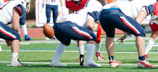 Fototapeta premium Football center snapping the ball in shotgun formation