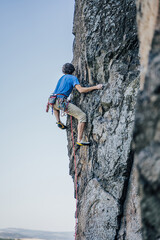A climber on a steep rock. Rock climbing, extreme adrenaline sport climbing.