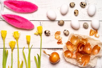 Foto auf Acrylglas Antireflex Easter eggs painted with natural dye, onion husk on a white wooden background and yellow spring flowers Narcis © Надежда Урюпина