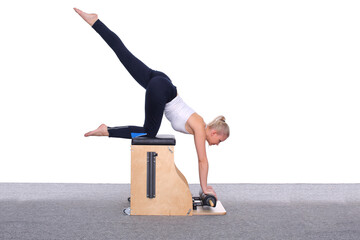 A 20-year-old female trainer practices Pilates on an elevator chair, lifting her leg high above her...