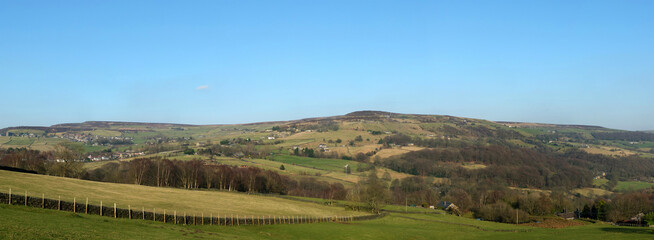 Fototapeta na wymiar panoramic view of the calder valley in west yorkshire with the village of midgley and dod naze surrounded by fields, woods and moorland
