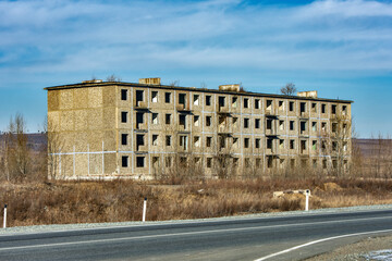 Fototapeta premium Abandoned panel house on the side of the road