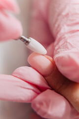 Manicure process. The master polishes the nail using an automated machine. Drill polish remover.