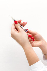 cosmetic syringe in the hands of a beautician on a white background