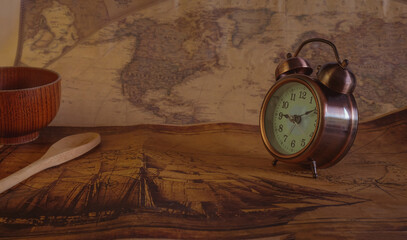 Classic Alarm clock on vintage paper map background.