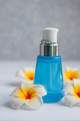 Obraz na płótnie Canvas moisturizing cream cosmetic in a bottle for skin care with mango flowers