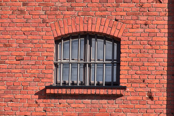 The old prison window on the red brick wall in Helsinki, Finland.