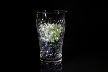 One empty crystal bowls symmetrically on a black background with white and black beads