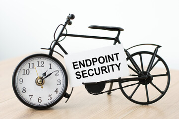 Text Endpoint Security on a white card next to the clock on an isolated light background