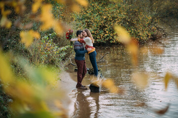 A romantic date, a walk in nature. Young couple of lovers together on the lake in early autumn