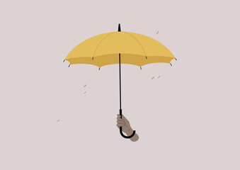 An isolated image of a human hand holding an open yellow umbrella, a rain protection © nadia_snopek