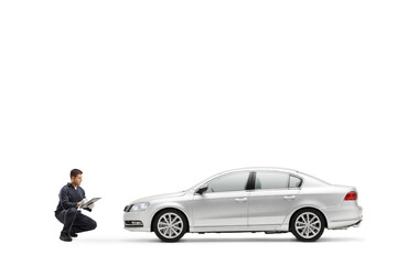 Auto mechanic worker checking a car and writing a document