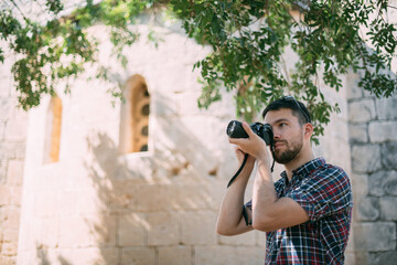 A man with a camera near the old temple