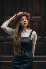 Fototapeta premium Woman wearing dress and a hat walking outside