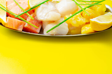 Fish pie mix, defrosted, skinless and boneless cod, dyed smoked haddock and salmon on the yellow background