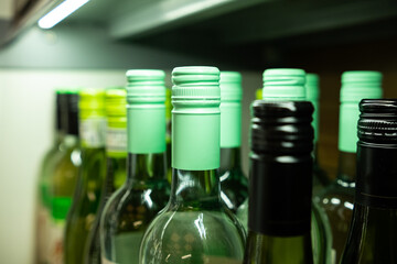 Close up of wine bottlenecks on a supermarket shelf - off-license - store - corner store. 