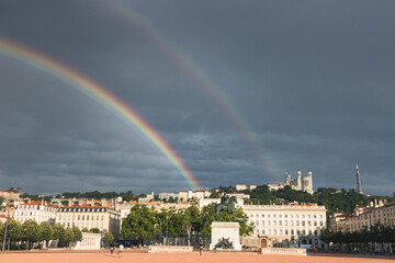 Arc en ciel au dessus de la place Bellecour et de la colline de Fourvière en été après un orage à Lyon en Rhône-Alpes