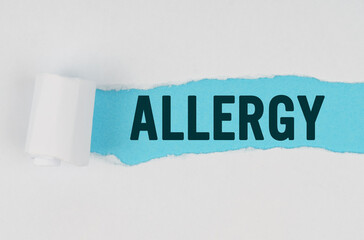 In the middle of a white sheet of paper, a tear is made under which, on a blue background, the inscription - ALLERGY