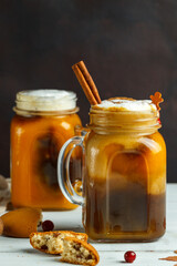 Two mugs with spicy latte on vegetable milk and homemade oatmeal cookies with raisins. close-up on a black background, vertically with space