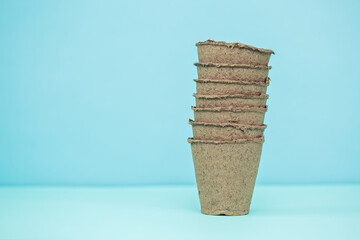 Pots for seedlings on a blue background. Copyspace.