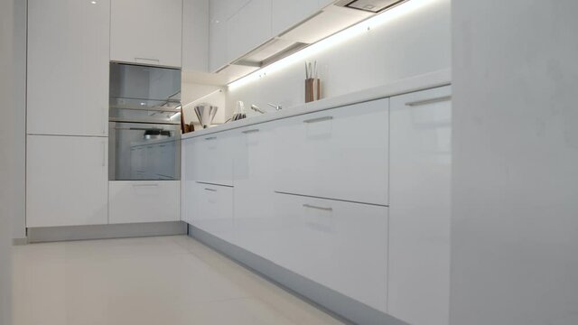White contemporary classic kitchen interior with dining table designed in modern style, dolly out camera movement