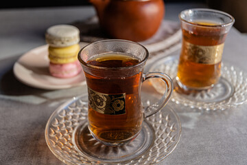French macaroons and tea in Turkish glasses with gold pattern.