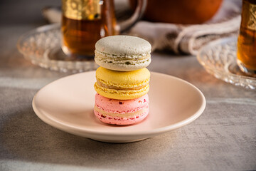 French macaroons and tea in Turkish glasses with gold pattern.
