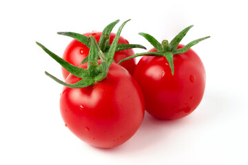 Ripe red cherry tomatoes with drops of water and green stalks isolated on white.