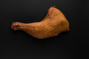 Appetizing smoked chicken legs, Ice, on a black background in isolation, poultry meat, chicken smoked meat