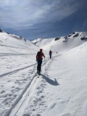 Fototapeta na wymiar Hiking on skis on the great swiss mountains. Fantastic view in winter time. Ski touring couple. Ski touring track