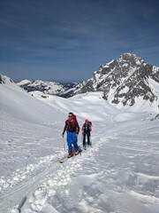 Fototapeta na wymiar Ski mountaineering couple toward the mountain pass in a nice track with sealskin. Winter landscape in glarus. Snow Skimo
