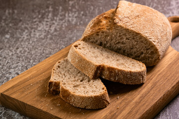 Fresh bread and slices on cutting board