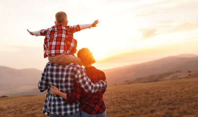 Happy family: mother, father and child  son  on nature on sunset