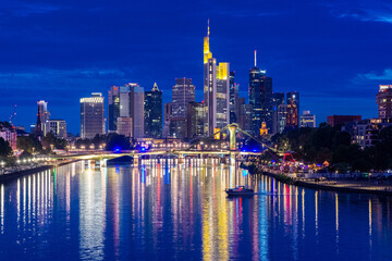 Naklejka premium FRANKFURT, GERMANY, 25 JULY 2020 Modern cityscape of the business district with reflection on the Main river at night