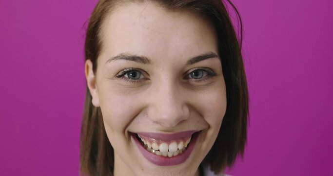 Positive woman closeup portrait smiling over pink backgorund